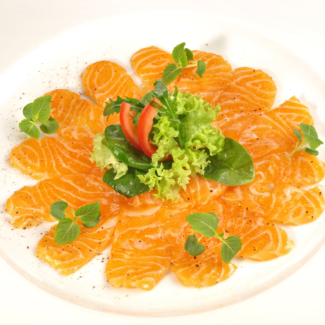 Elegantly plated Ora King Salmon fillet with herb garnish and lemon for a special occasion dinner