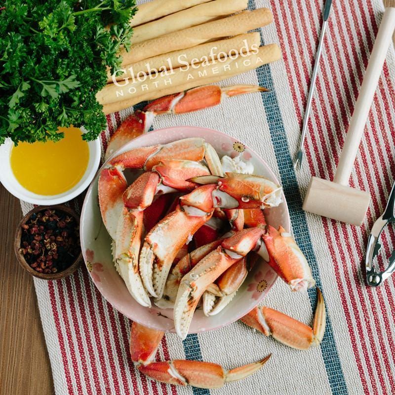 A plate of steamed Dungeness crab legs with lemon and butter dipping sauce