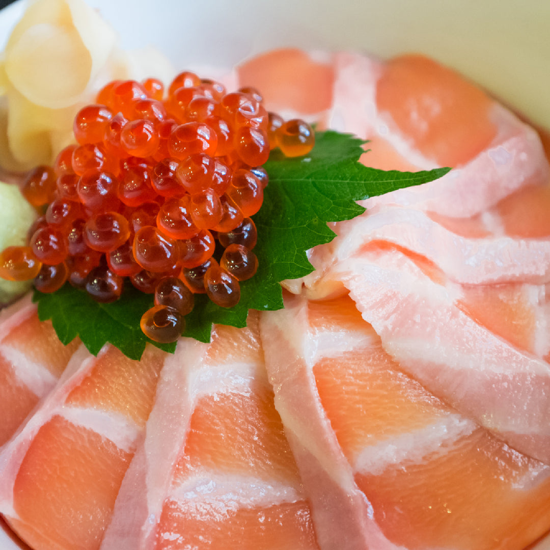 Golden crispy ikura croquettes on a serving plate garnished with chives and nori flakes, with a small dish of salmon roe alongside for topping