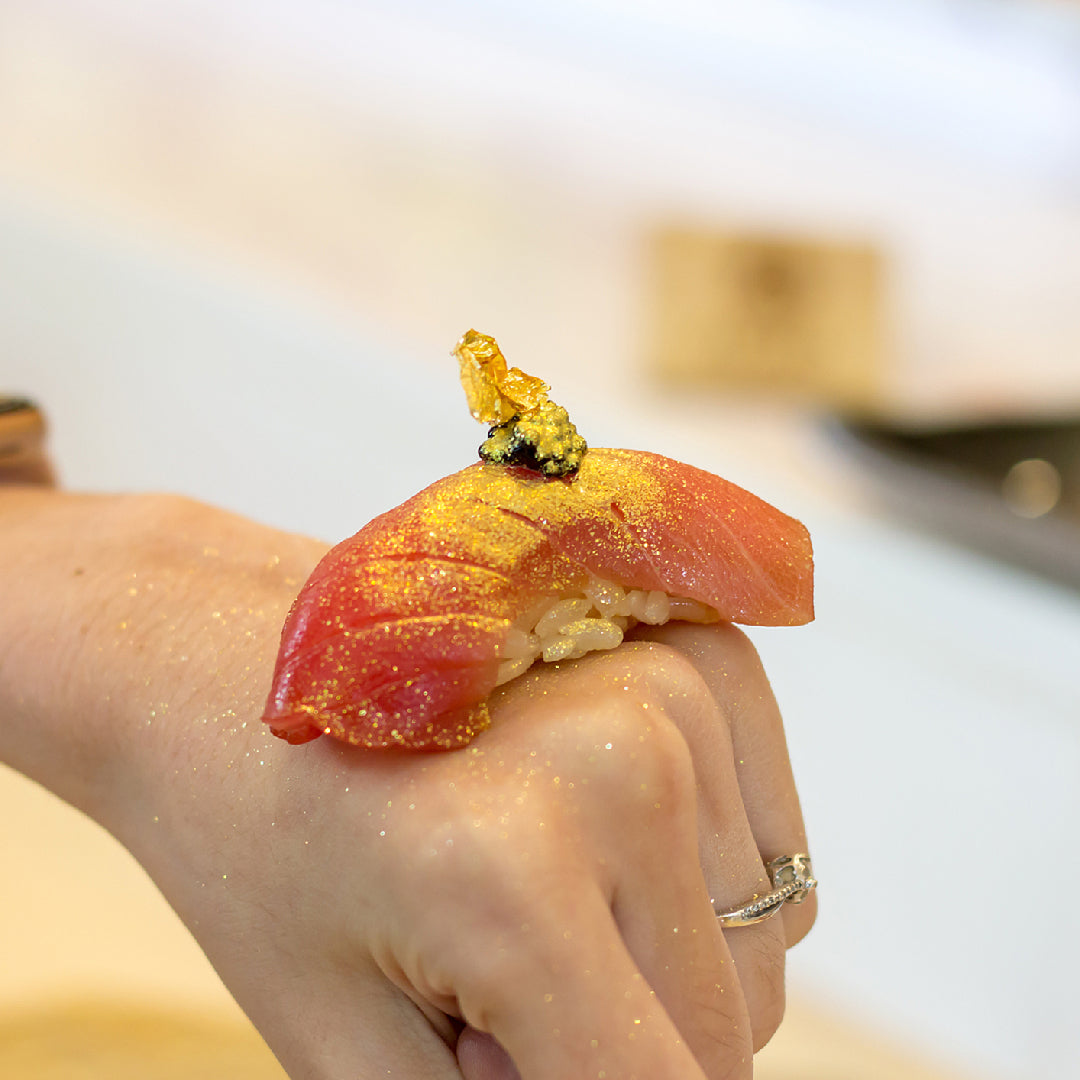 Side-by-side comparison of bluefin tuna and bigeye tuna fillets on a cutting board, showing their distinct red color and marbling differences