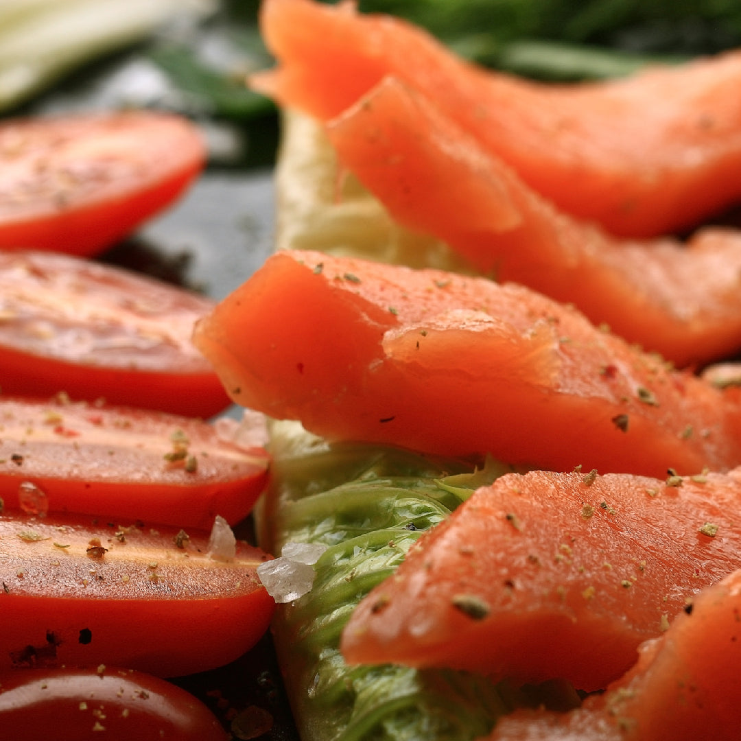 Beautifully marbled Ora King Salmon fillet on a wooden board showcasing its vibrant orange color and rich texture