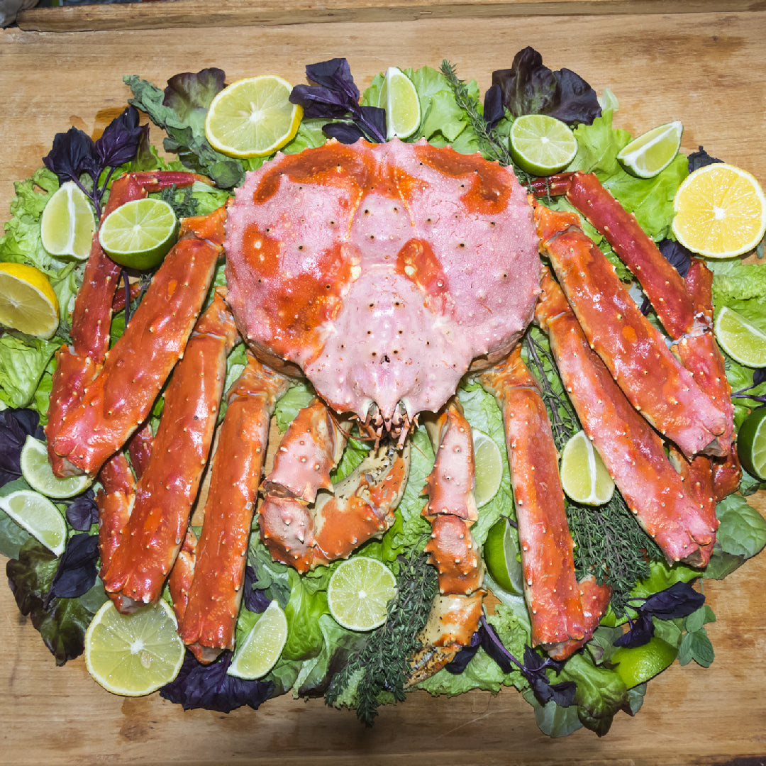 Alaskan red king crab legs in a seafood market display with price tags, showing premium king crab available for purchase online and in-store