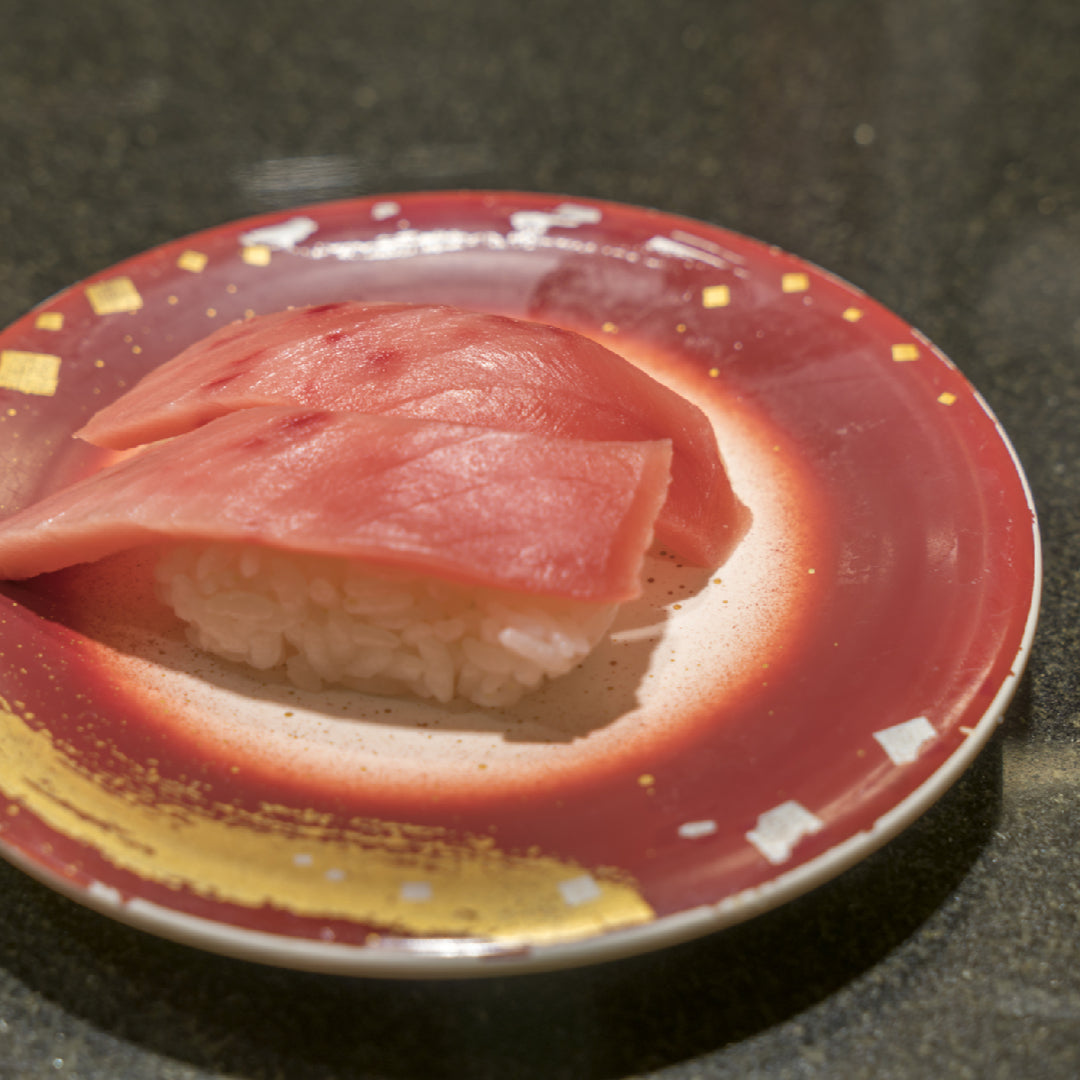 Golden-crusted pan-seared bluefin tuna steak sliced to reveal a rare pink center, plated with sesame seeds and green onions