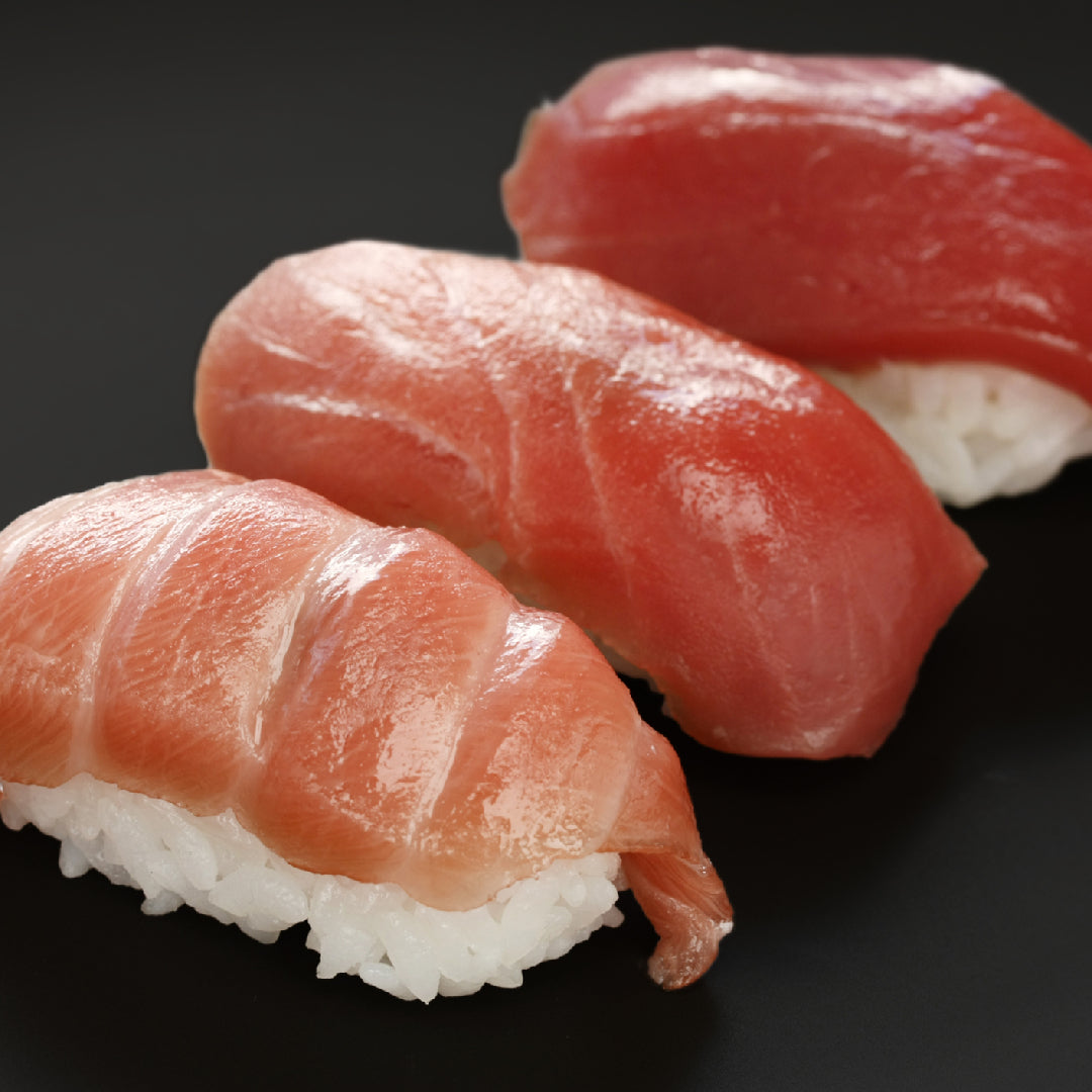 Fresh Bluefin tuna steak sliced to show rich red flesh, plated with lemon and herbs to highlight its nutritional quality