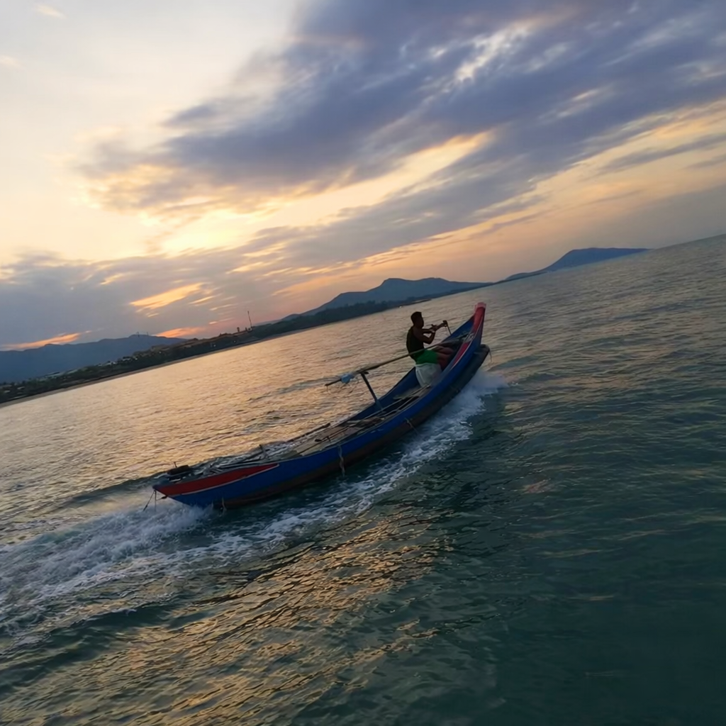 Small Vietnamese fishing boat leaving Lang Co Bay at dusk heading into the South China Sea