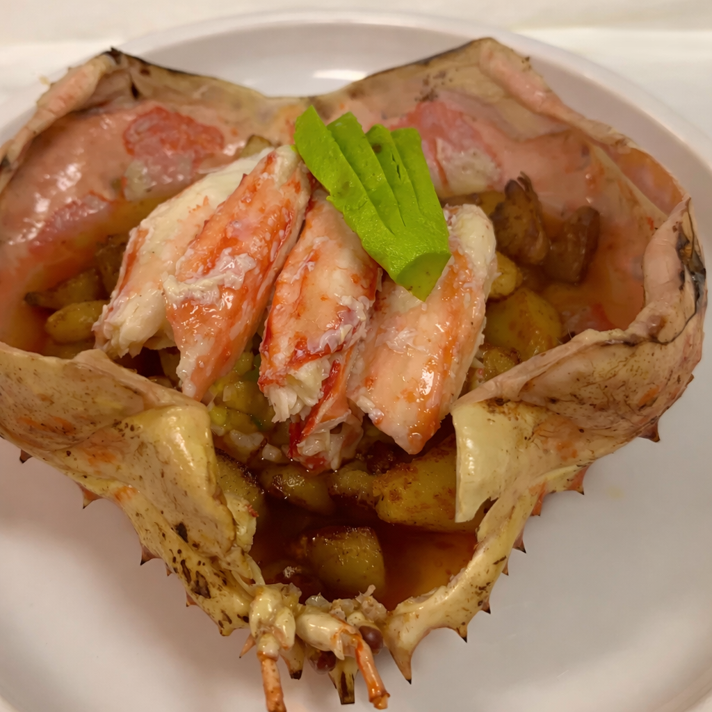 Luxury king crab dinner served in cleaned king crab shell with sushi rice, mango salsa, avocado, cracked king crab legs, and king crab butter