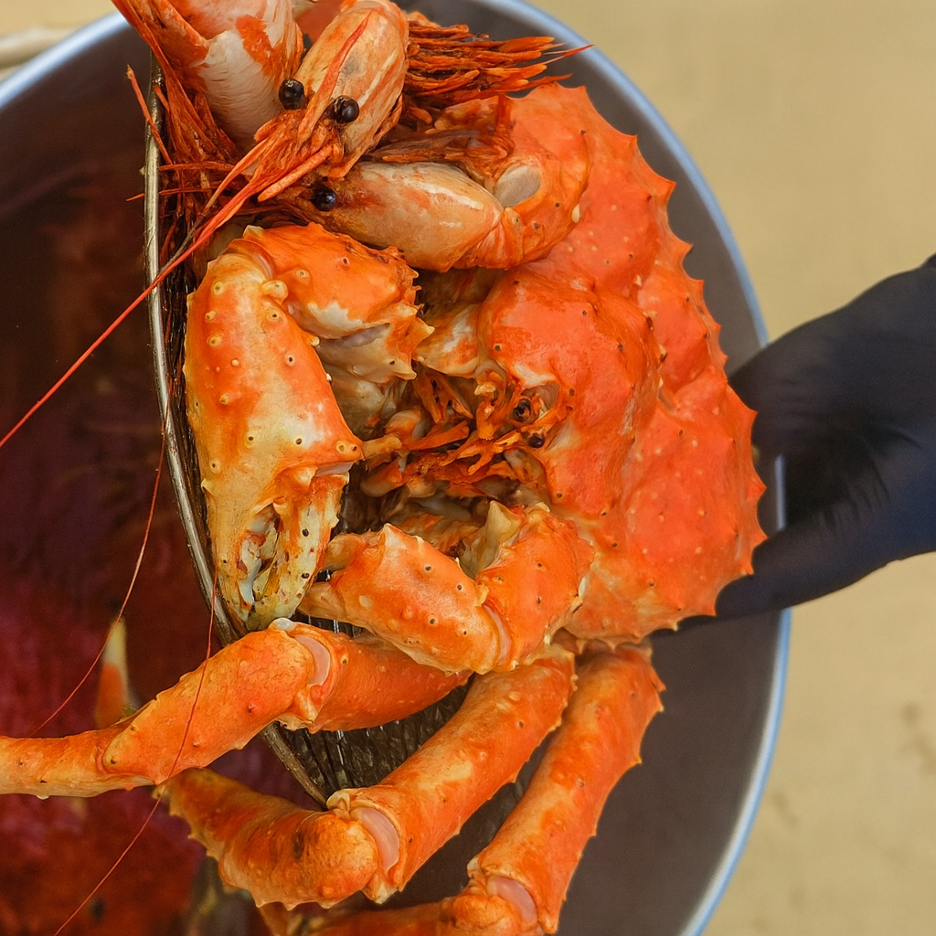 Luxury seafood feast platter with live king crab legs, lobster halves, Dungeness crab, spot prawns, and Beluga caviar in the center