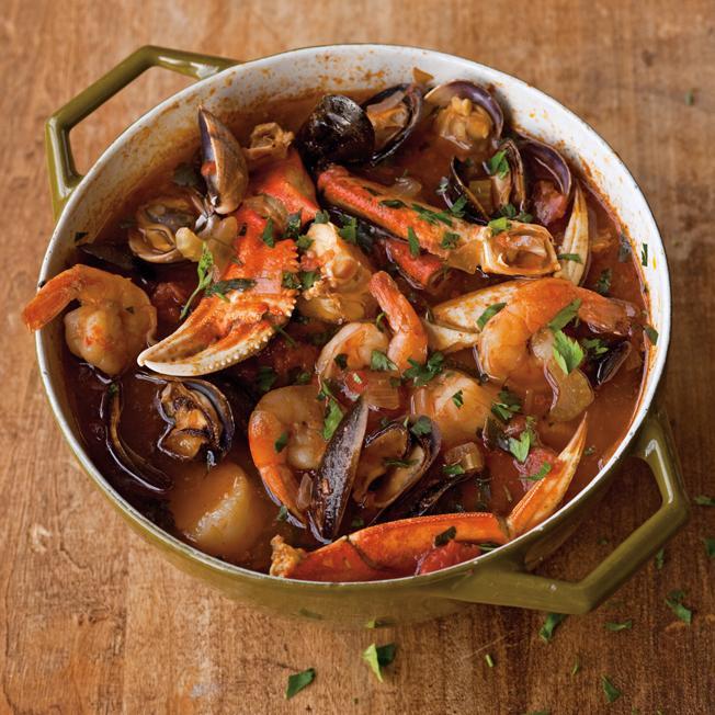 A bowl of Dungeness crab cioppino seafood stew with shrimp, clams, and mussels in a rich tomato broth