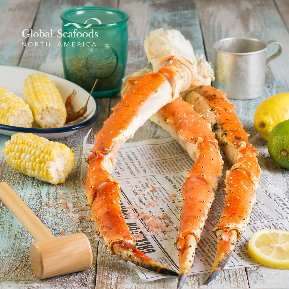 Baked King Crab legs with garlic butter, fresh parsley, and lemon wedges on a serving platter