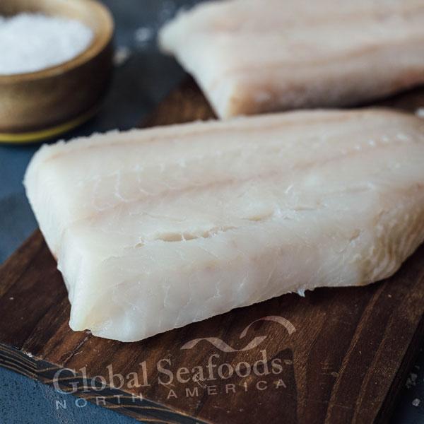 Fresh Alaskan white fish fillets including Pacific cod and pollock on ice