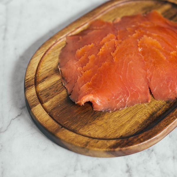Elegant smoked salmon appetizers on a serving board with cream cheese, capers, dill, and cucumber rounds