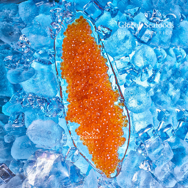 Glistening orange-red Ikura salmon roe pearls served on sushi rice with nori and chopsticks
