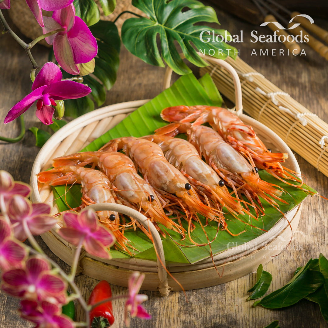 Whole spot prawns arranged on a leaf in a basket