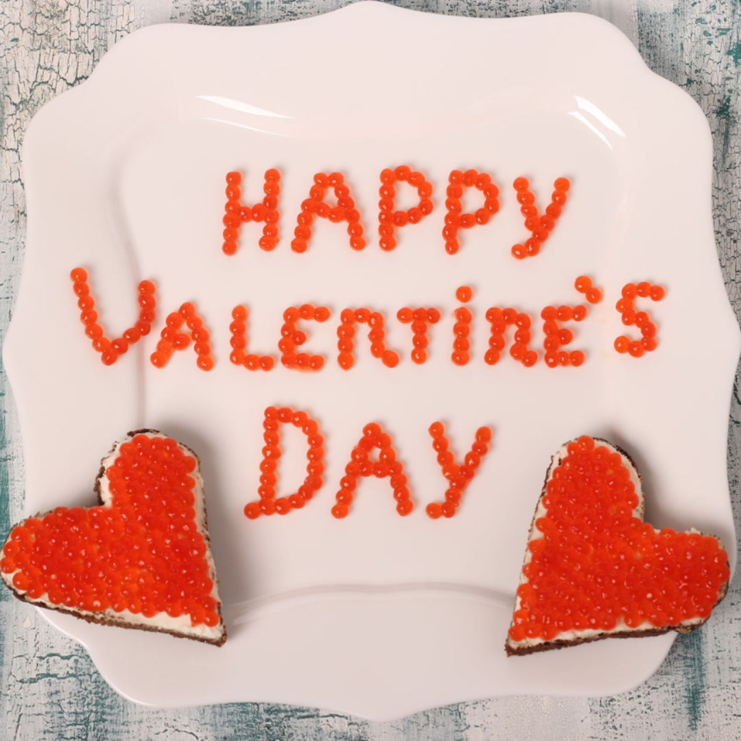 Elegant Valentine's Day dinner setting with a dish of red caviar, garnished and ready to be served
