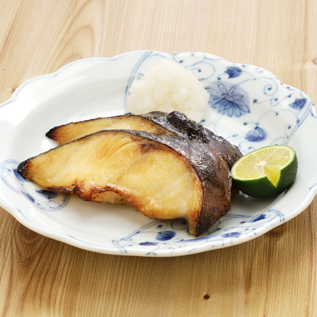 Plated sablefish fillet with a golden-brown sear, garnished with a lemon wedge and accompanied by a vibrant, fresh side salad, showcasing a healthy and elegant meal presentation