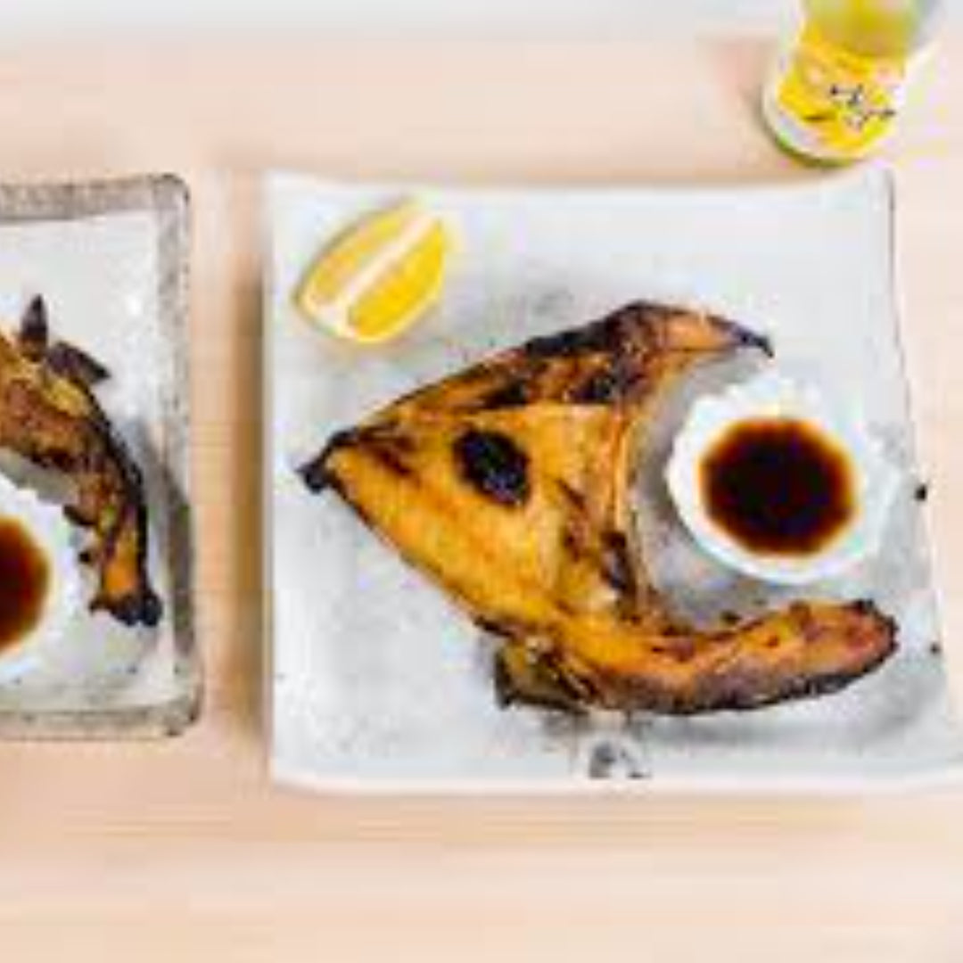 Grilled Hamachi fish skewers with bell pepper and red onion, garnished with sesame seeds and green onions on a serving platter