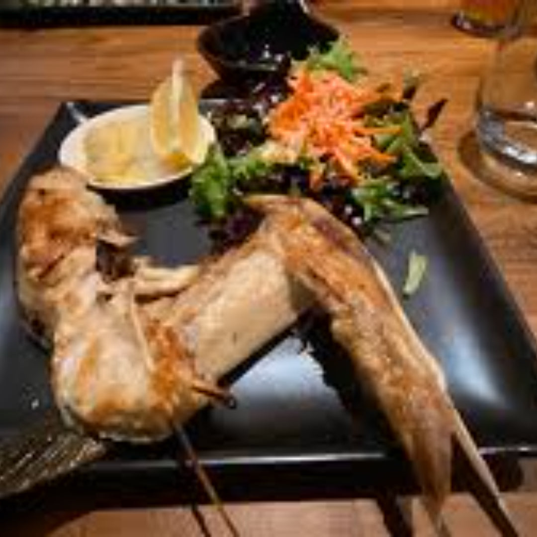 Golden crispy Hamachi fish katsu cutlets served with shredded cabbage, tonkatsu sauce, and lemon wedges on a white plate