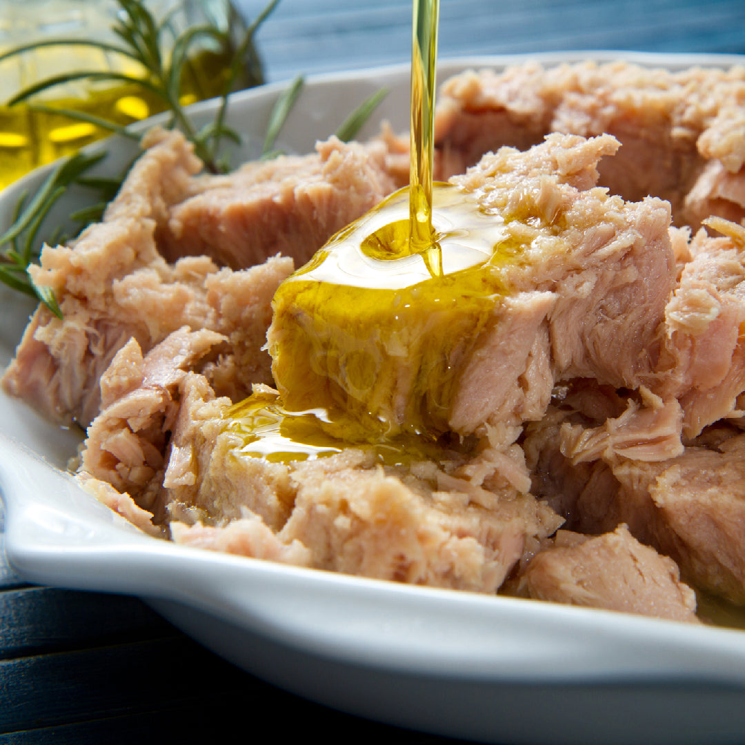 Selection of premium albacore tuna products including fresh tuna steaks and sushi-grade tuna blocks on a kitchen counter