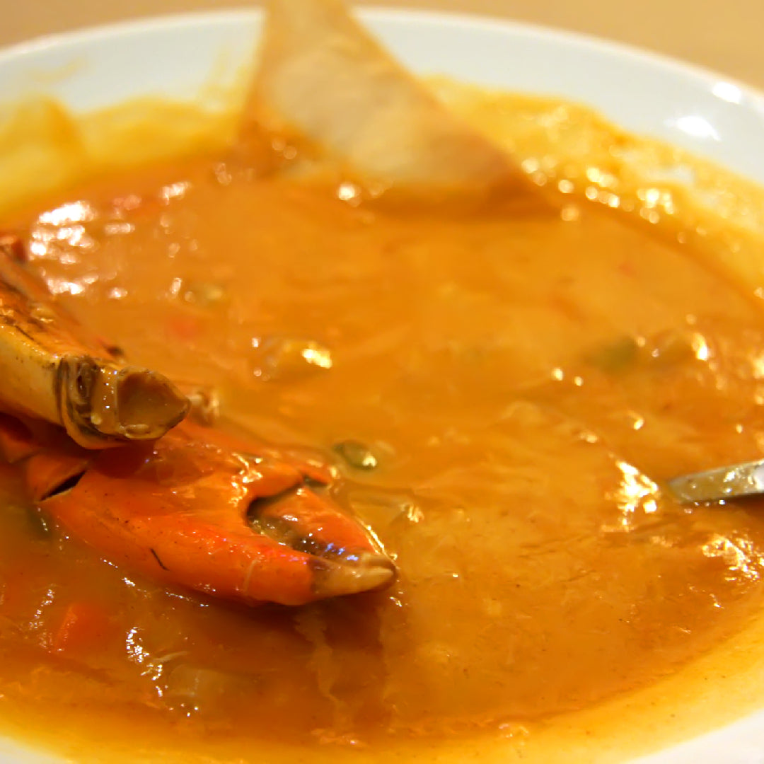 Homemade Dungeness crab bisque in a bowl with cream swirl and fresh parsley garnish