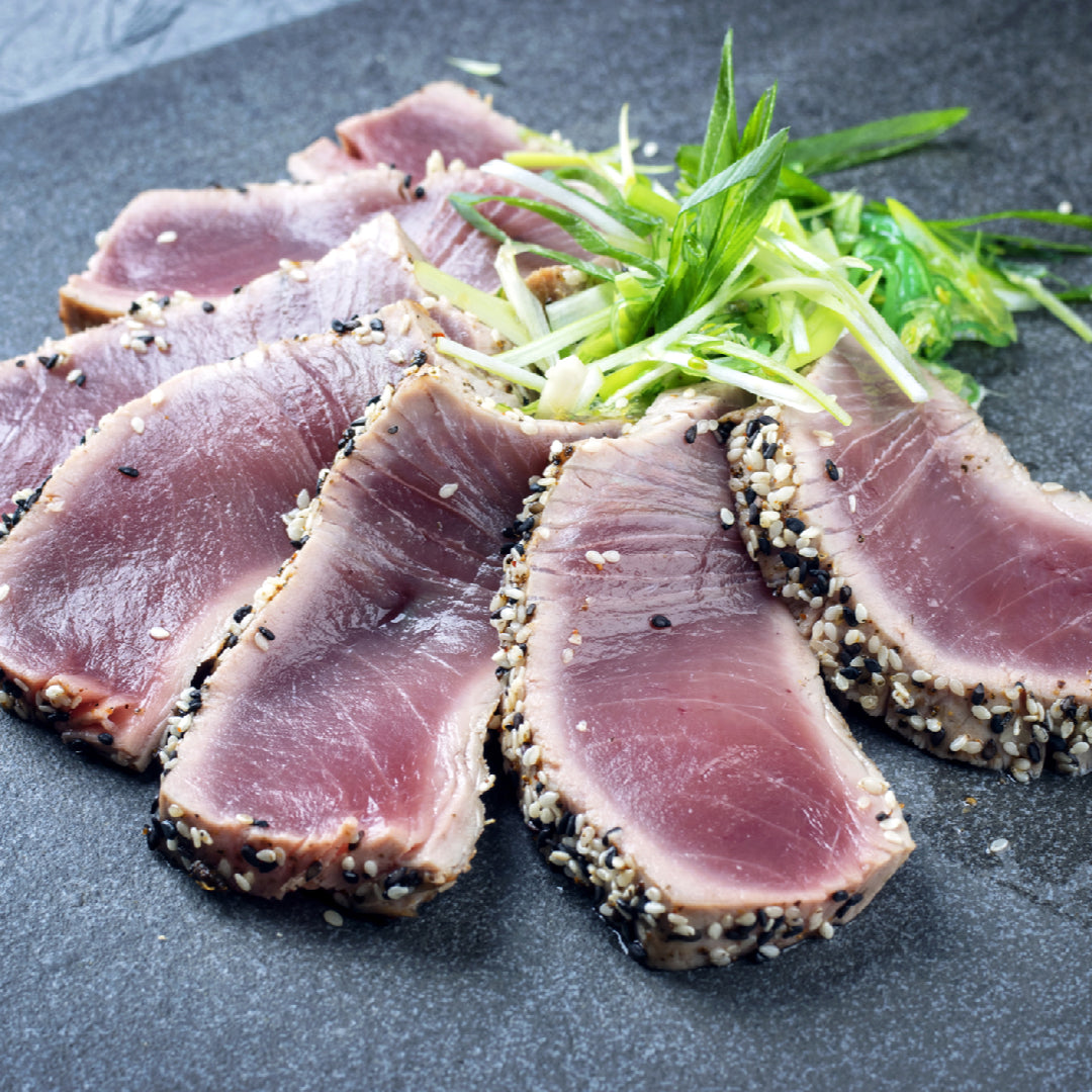 Five Bluefin tuna dishes including sashimi, seared sesame-crusted steak, tartare with avocado, poke bowl, and grilled tuna arranged on elegant plates