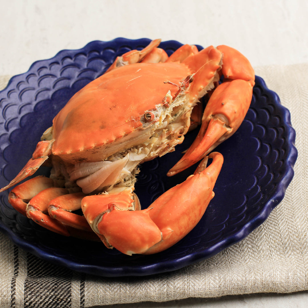 A plate of freshly cooked crab legs with lemon and herbs, representing the health benefits and nutritional value of crab as a lean protein source