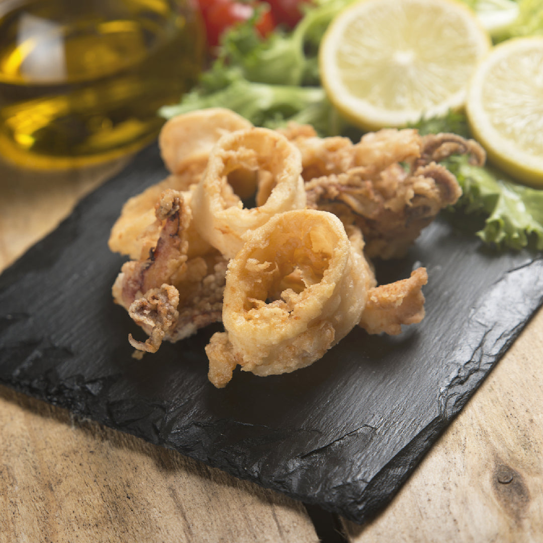 Golden crispy fried calamari rings served with marinara dipping sauce and lemon wedges