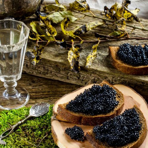 Caviar served on a spoon alongside fresh ingredients highlighting its nutritional and health benefits