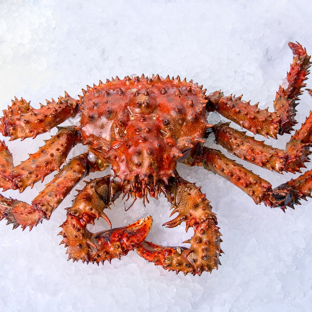 A plate of steamed Alaskan king crab claws garnished with lemon wedges and fresh herbs, highlighting their nutritional value as a healthy seafood option