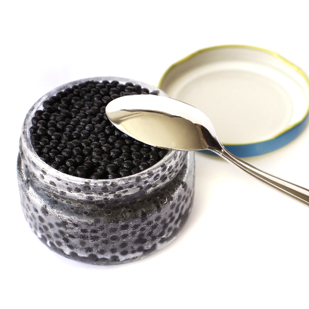 Vodka martini garnished with Beluga caviar pearls in a chilled crystal glass