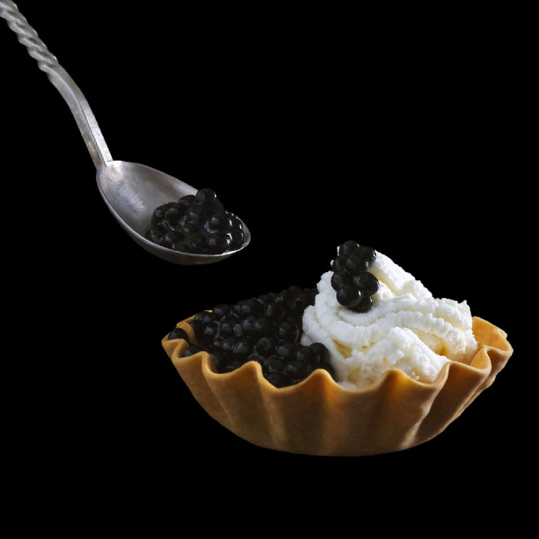 Elegant Beluga caviar gift set with mother-of-pearl spoon and Champagne on a marble surface
