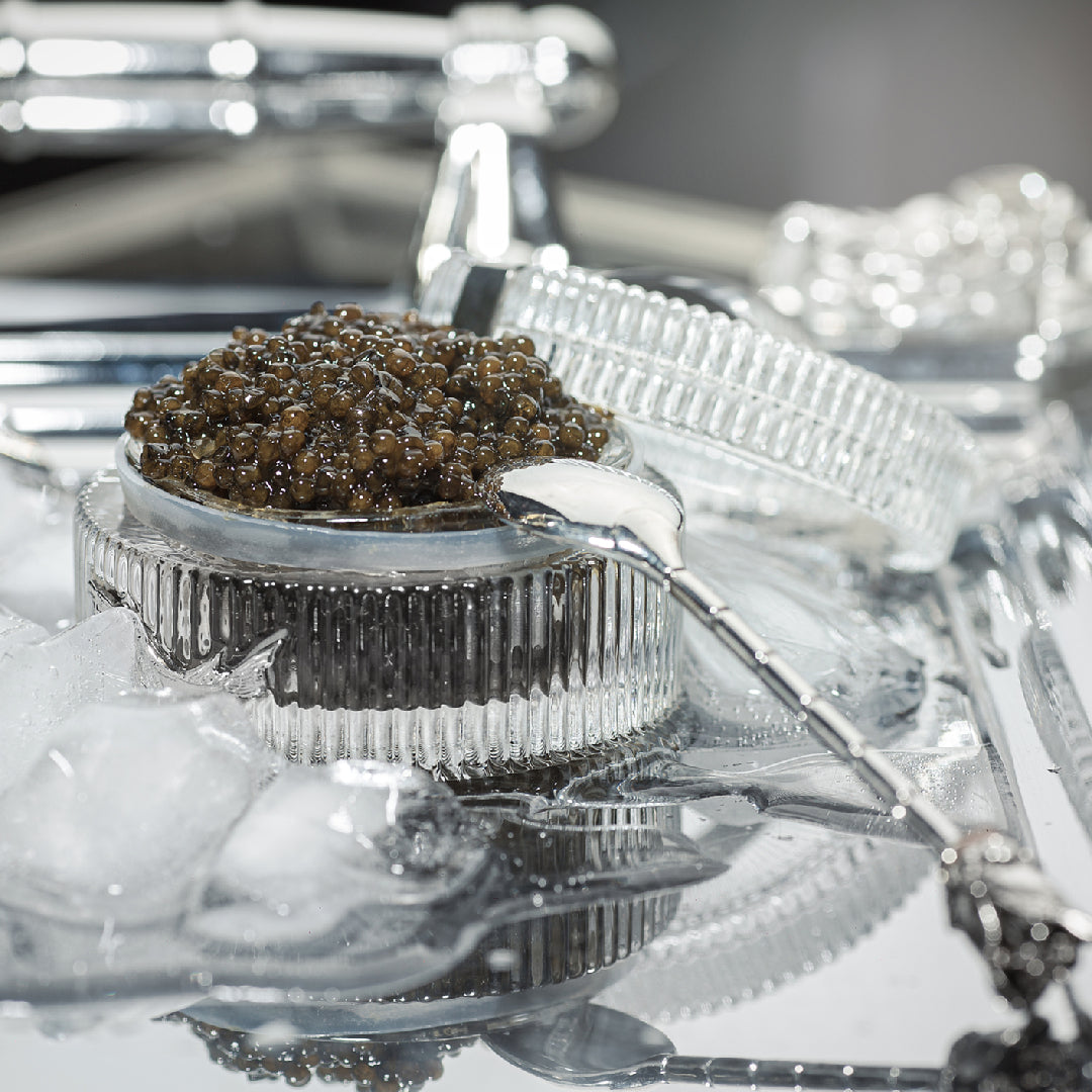 Osetra caviar served on warm blinis with crème fraîche and fresh chives