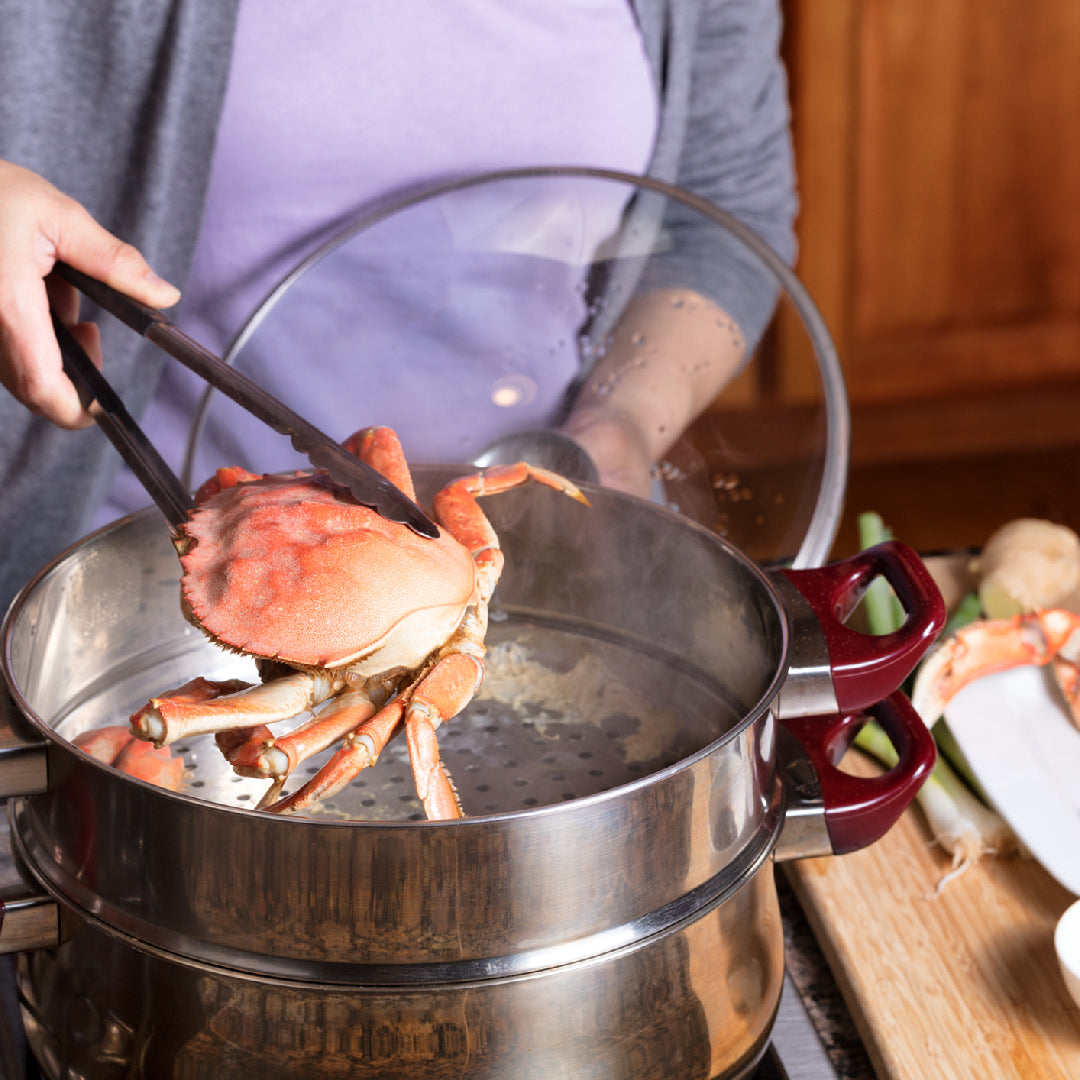 Frozen Dungeness crab legs on a plate with melted butter, lemon wedges, and fresh herbs