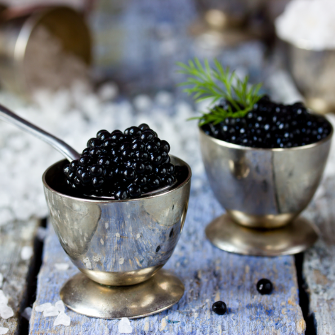 Fluffy silver dollar pancakes topped with glistening caviar pearls and crème fraîche garnished with fresh dill