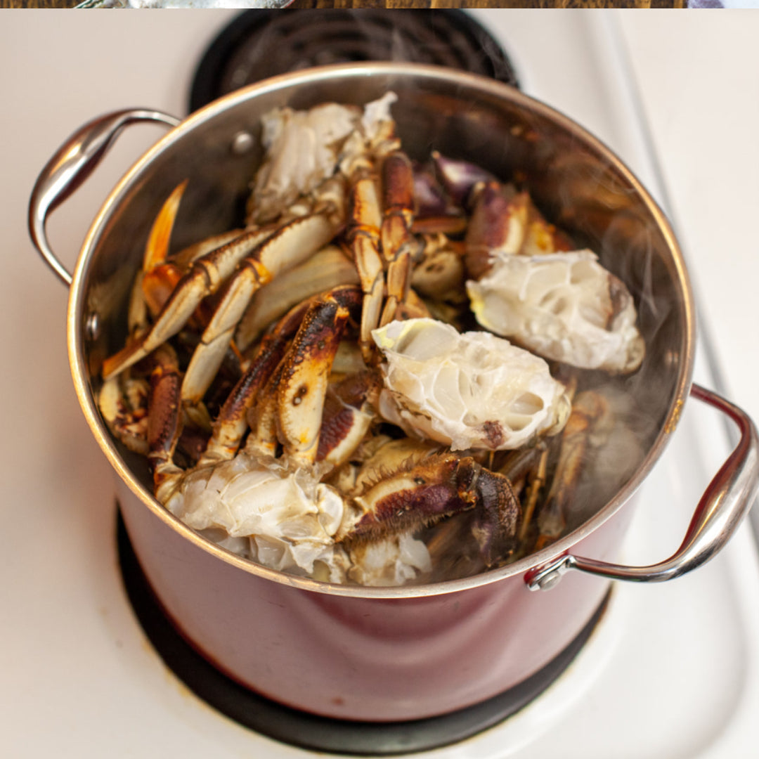 Crab legs being boiled in a large pot of seasoned water with lemon slices, garlic, and bay leaves