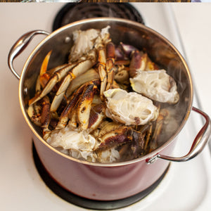 Crab legs arranged in a pot filled with water, ready to be boiled