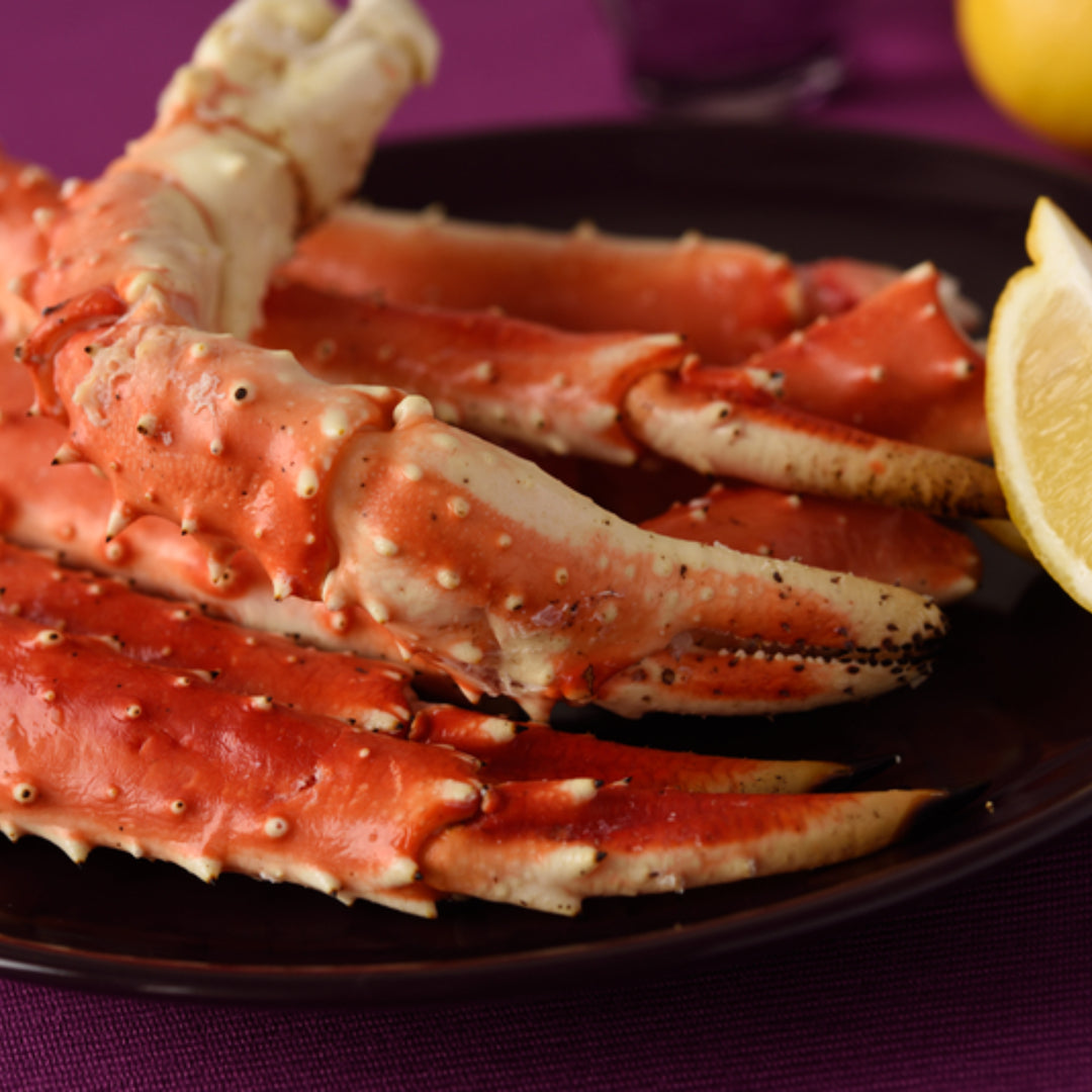 Steamed king crab legs served with garlic butter and lemon wedges on a seafood platter