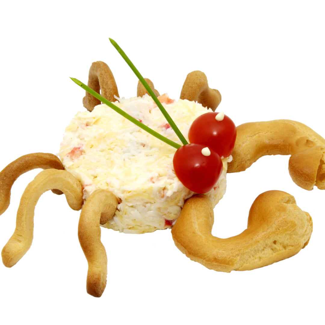 Deliciously prepared crab butter in a small dish, garnished with fresh herbs, alongside a plate of steamed crab legs ready for dipping
