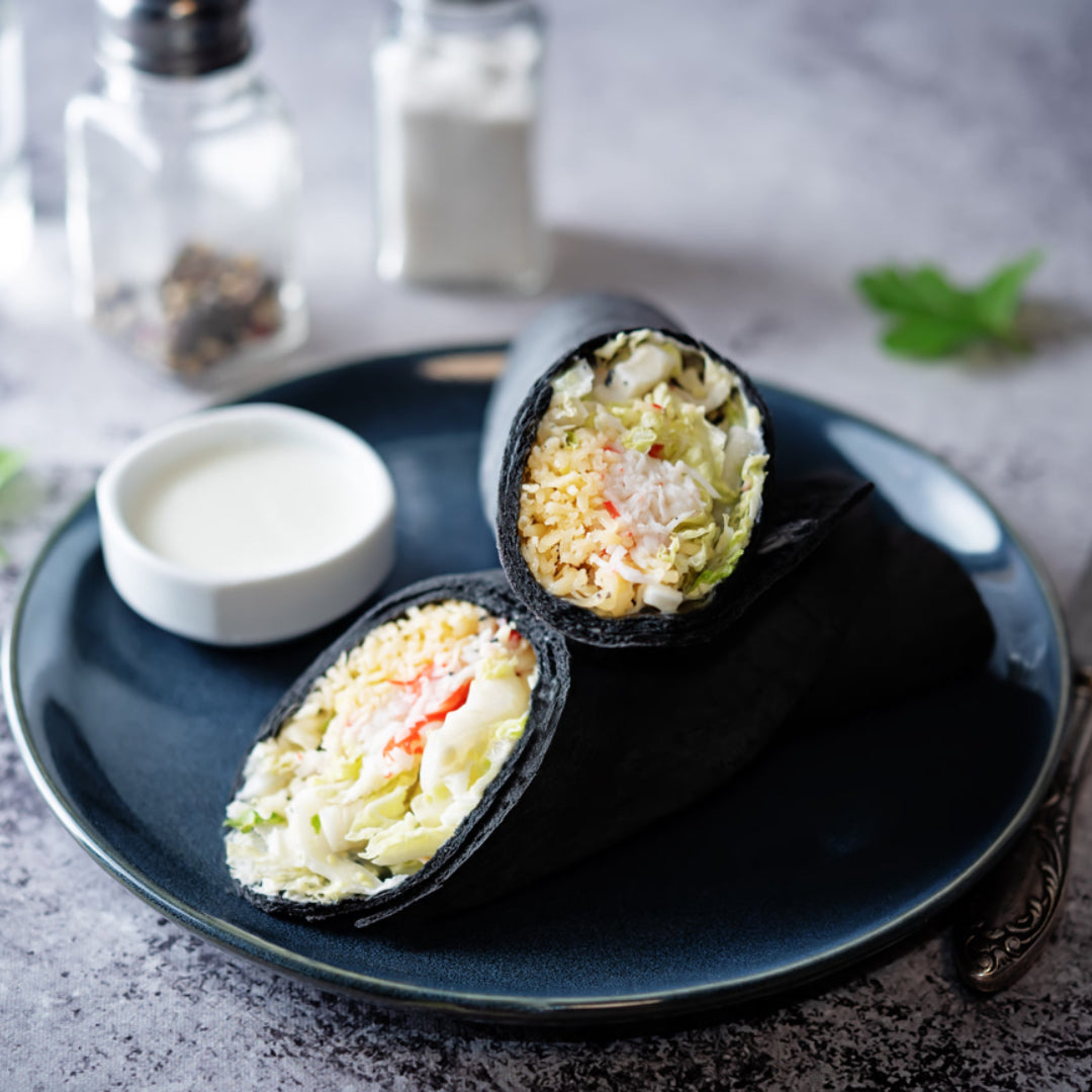 Golden crab quesadilla sliced into quarters with sour cream and salsa