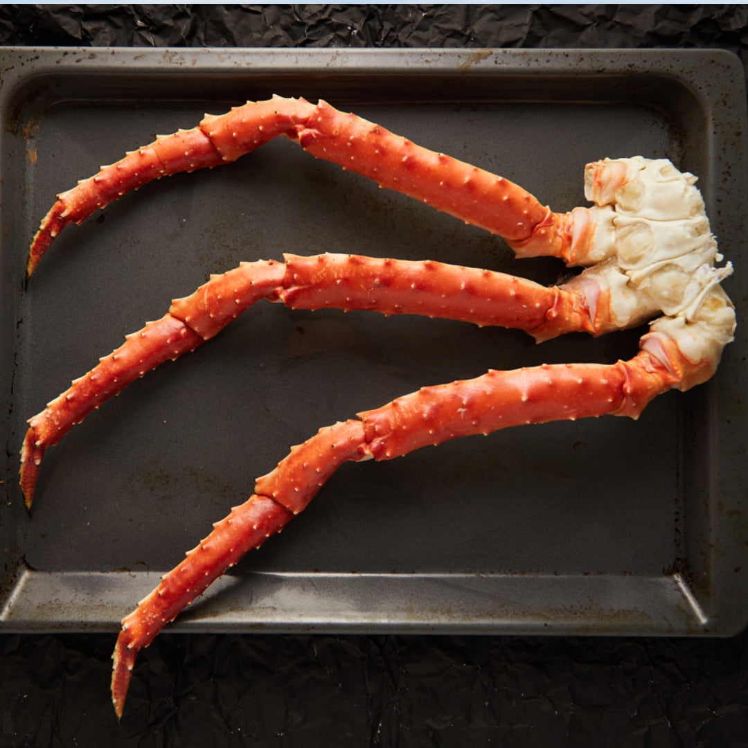 King crab legs being steamed in a large pot with a lid, the most effective method for reheating pre-cooked frozen crab legs