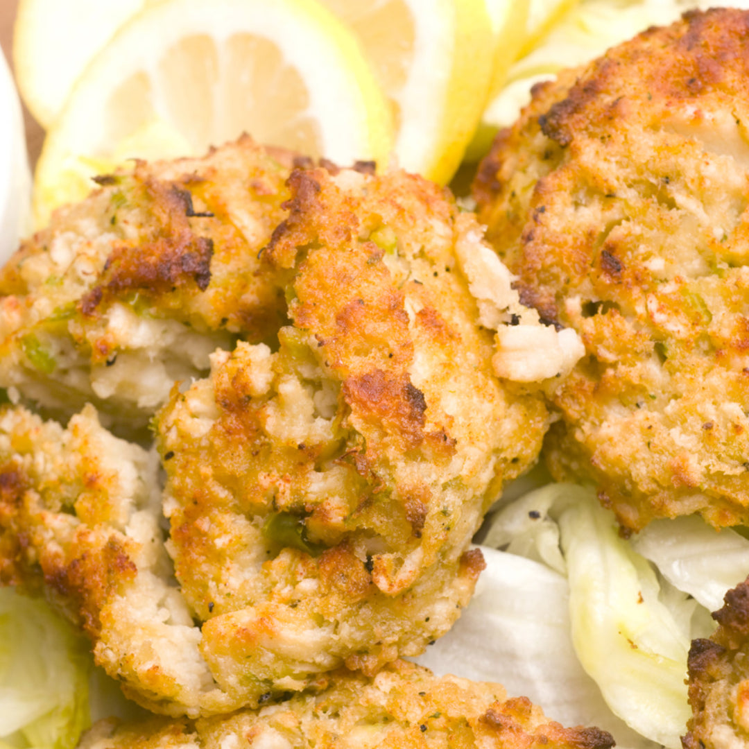 Golden brown crab cakes made with fresh Dungeness crab, served with lemon and tartar sauce