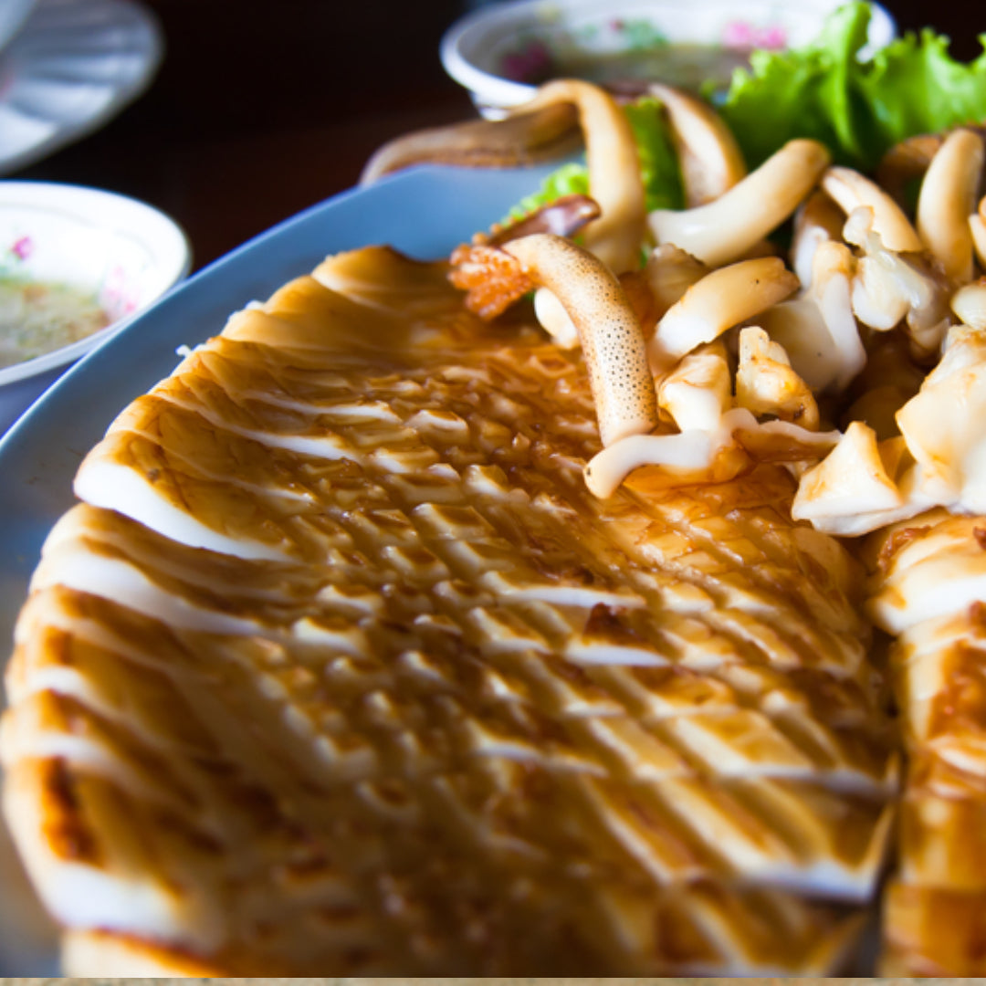 Golden crispy calamari steak served with lemon wedges and tartar sauce