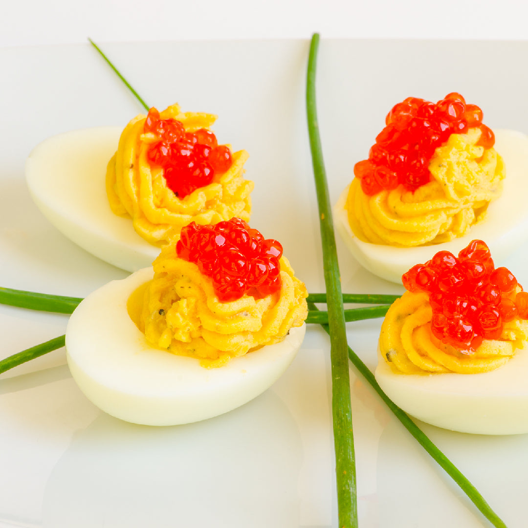 IKURA caviar – glistening red-orange salmon roe pearls served on a crystal spoon over ice, known for their rich buttery flavor, satisfying pop texture, and high omega-3 content – a Japanese delicacy and gourmet luxury