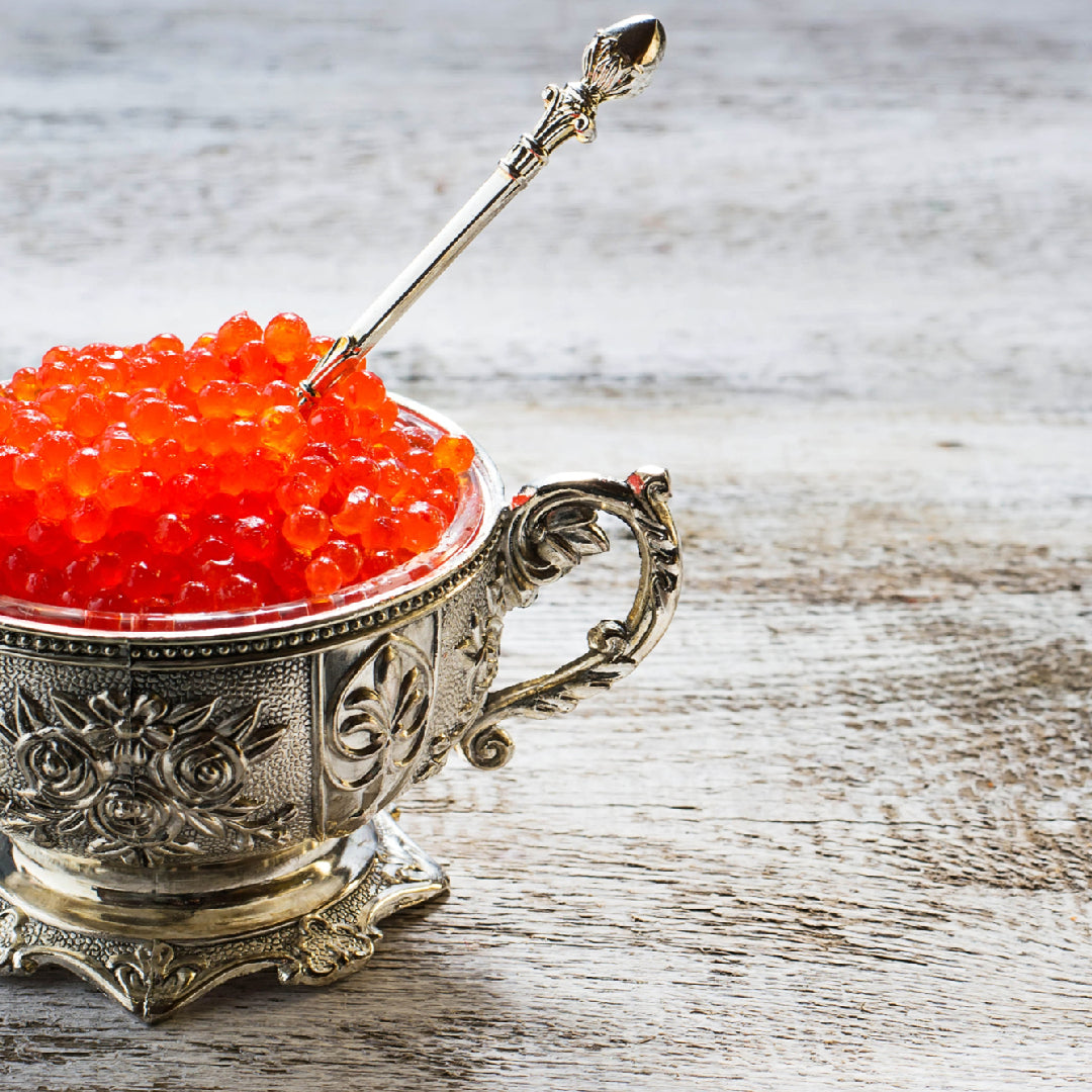 How to store IKURA caviar – salmon roe in a sealed glass jar on a bed of crushed ice at the correct refrigerator temperature of -2°C to 4°C, with a mother-of-pearl spoon for serving to avoid metallic taste