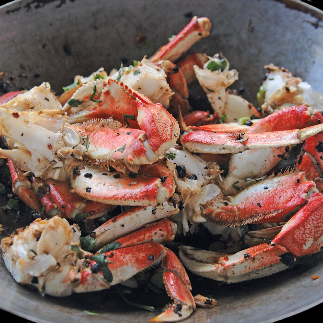 Dungeness crab legs served alongside grilled steak for a surf and turf dinner