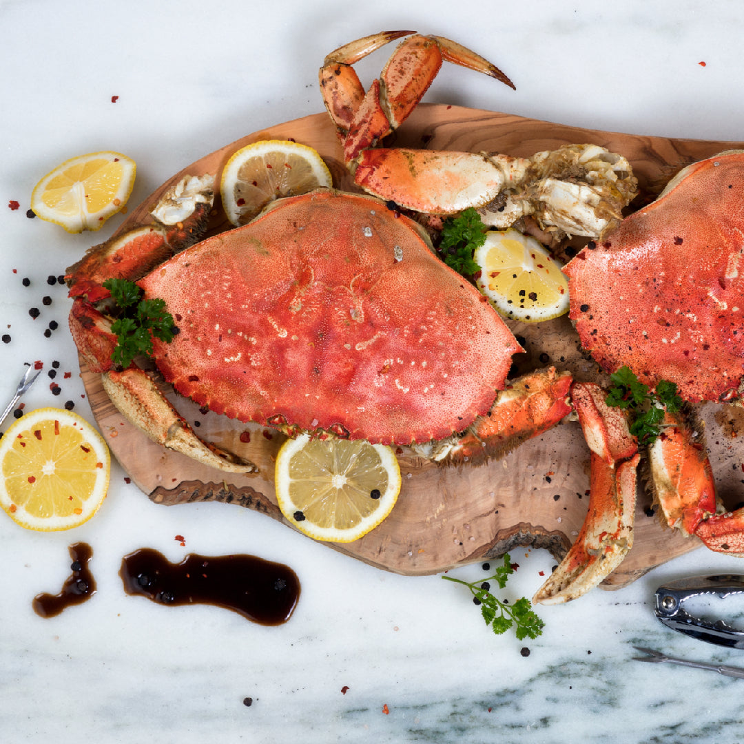 Dungeness crab legs served with grilled vegetables garlic butter rice and coleslaw on a seafood feast table