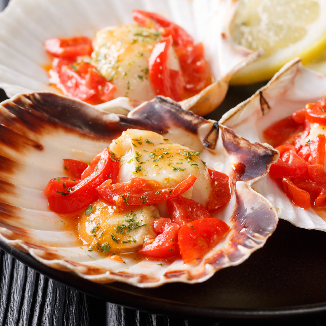 Seared diver scallops over fettuccine pasta with garlic butter sauce and fresh parsley