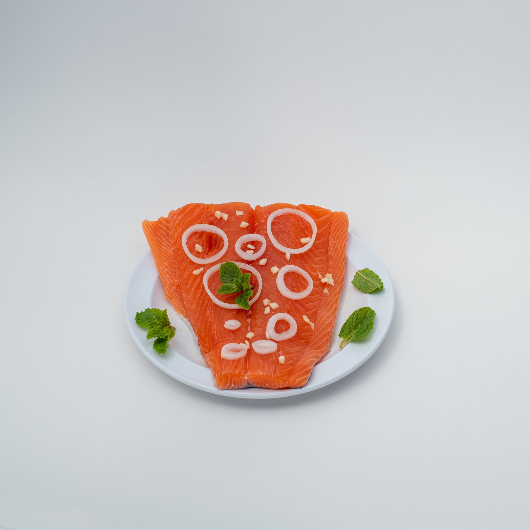 Nutritious Ora King salmon fillet rich in omega-3s served on a plate with fresh vegetables, lemon, and herbs representing a healthy balanced meal