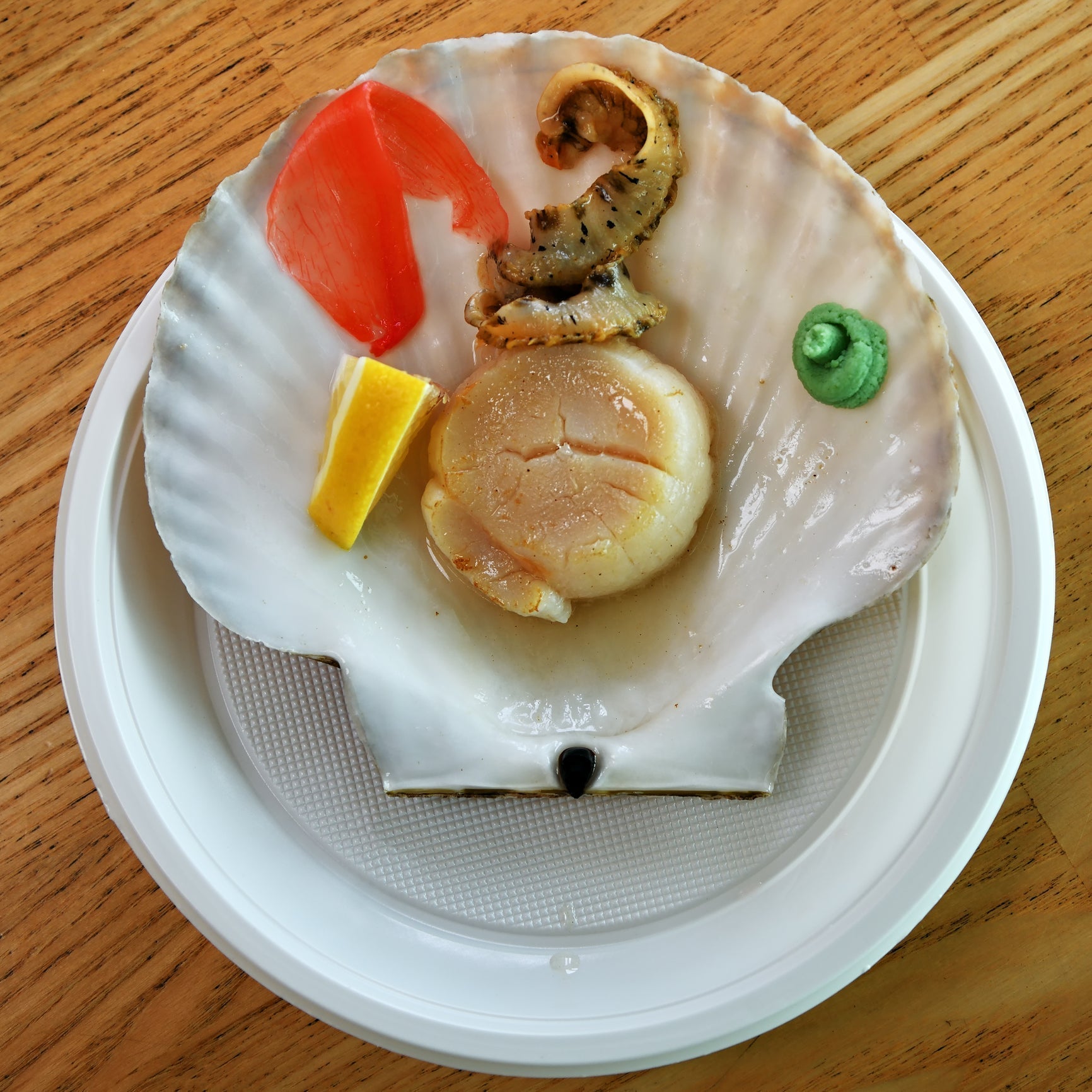 Smoked scallops on a plate with a lemon wedge and fresh parsley