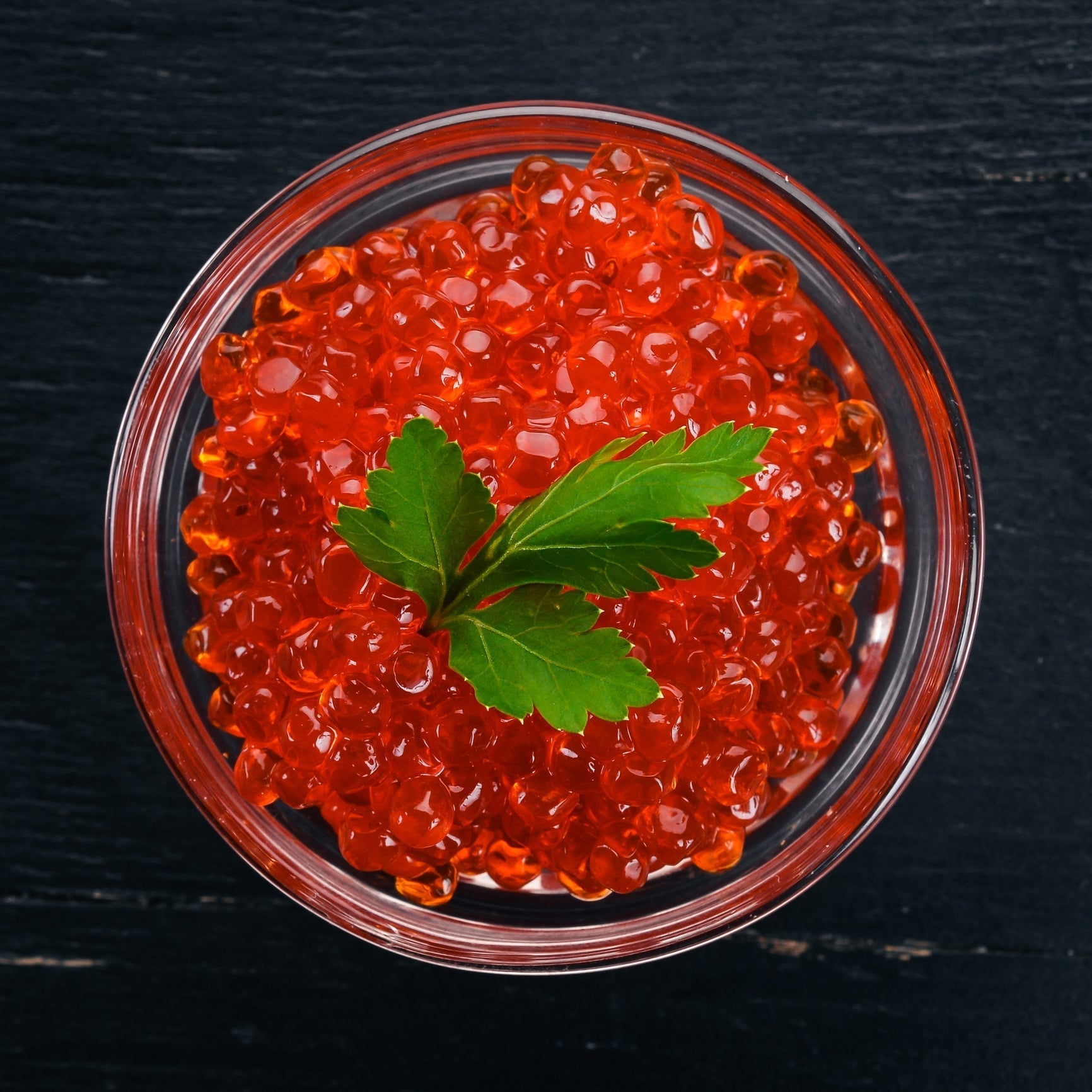 Fresh salmon roe being rinsed and prepared in a bowl, ready for brining or soy marination