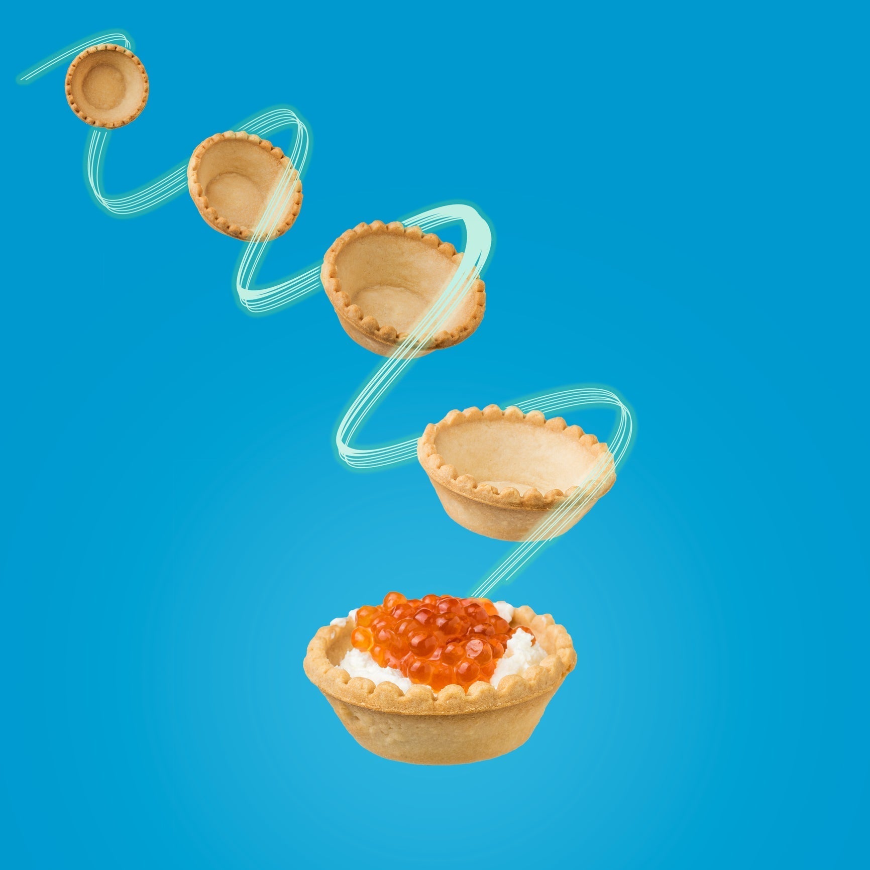 Alaska salmon red caviar in a glass bowl with a spoon, surrounded by blinis, cream cheese, and fresh dill